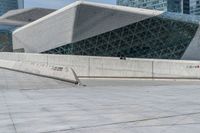 a man riding a skateboard across a cement floor next to tall buildings overhangs