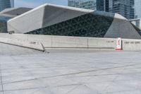 a man riding a skateboard across a cement floor next to tall buildings overhangs