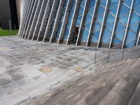 steps leading up to a very large modern building with many diagonal glass walls behind it