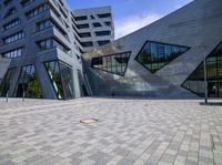 the building with a lot of windows is located inside the courtyard by two large bricks and concrete