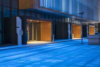 empty blue sidewalk next to buildings on a city street at sunset or sunrise hour or night