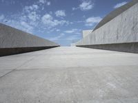 empty concrete walkway with blue sky and clouds in the background that appears to be empty