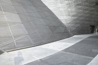 a man rides his skateboard through an outdoor courtyard area on the sidewalk in front of the building