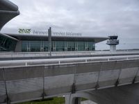 an airport terminal with stairs and skyway in the background of an overcast sky