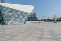 there is a very small structure in the city with a large glass building next to it