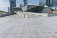 a skateboarder rides down a walkway in a city setting with many skyscrapers