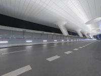 a couple of white pillars with lights on them at the airport and street level on a busy road