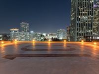 the large clock is in the middle of the empty square with skyscrapers in the background