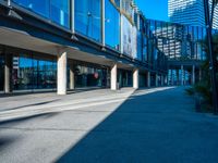 the shadows of buildings and trees are reflected on the windows of the building's glass wall