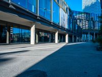 the shadows of buildings and trees are reflected on the windows of the building's glass wall