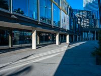 the shadows of buildings and trees are reflected on the windows of the building's glass wall