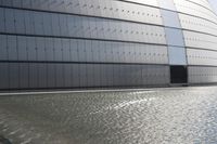 a person on a skateboard in front of a big building with a curved roof