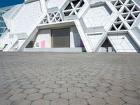 an open area on a building with white walls and a pink door in front of it