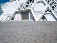 an open area on a building with white walls and a pink door in front of it