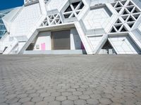 an open area on a building with white walls and a pink door in front of it