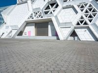 an open area on a building with white walls and a pink door in front of it