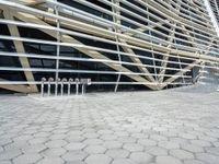 the large building has a lot of balcons on it and a concrete sidewalk next to it