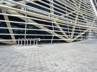 the large building has a lot of balcons on it and a concrete sidewalk next to it