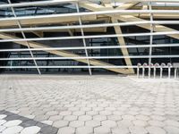 a bunch of poles in front of a very large building with some windows and a roof