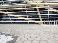 a bunch of poles in front of a very large building with some windows and a roof