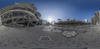 the reflection in a fisheye lens on some building that is outside of a park