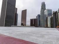 skyscrapers in the middle of a city near a sidewalk with a red marker pointing to them