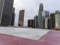 skyscrapers in the middle of a city near a sidewalk with a red marker pointing to them