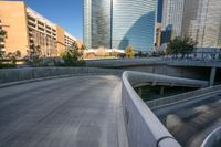 people are walking on a pedestrian bridge over water in the city streets, in the foreground of buildings and traffic