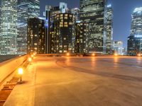 a bench on the ground at night with city lights on it's tops, while others of the rest below a city block