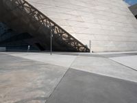 a man is walking outside near a large white structure in the daytime light with blue skies above