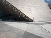 a man is walking outside near a large white structure in the daytime light with blue skies above