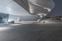 the lights on in an empty space that appears to have been designed like a curving structure