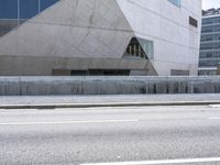 a man riding down an empty city street in front of large glass and concrete building
