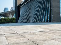 there is a skate board laying on the floor by a building with tall buildings in the background