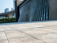 there is a skate board laying on the floor by a building with tall buildings in the background