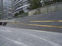 an urban area with stairs and a curved walkway with a bench and umbrellas on it