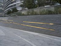 an urban area with stairs and a curved walkway with a bench and umbrellas on it