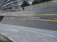 an urban area with stairs and a curved walkway with a bench and umbrellas on it