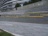 an urban area with stairs and a curved walkway with a bench and umbrellas on it
