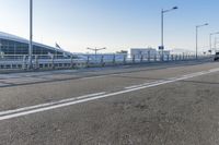 a car driving through an airport with white and blue stripes on the road, at the edge of a bridge