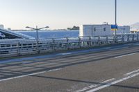 a car driving through an airport with white and blue stripes on the road, at the edge of a bridge