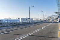 a car driving through an airport with white and blue stripes on the road, at the edge of a bridge