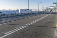 a car driving through an airport with white and blue stripes on the road, at the edge of a bridge