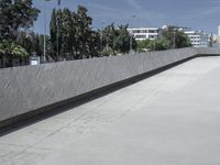 a young man riding a skateboard down a cement covered road area next to trees