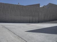 this is a picture of a large concrete block wall that stretches over the top of the sidewalk