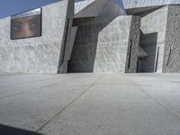 the sidewalk in front of a building with some kind of structure on the side of it