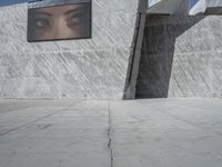 the sidewalk in front of a building with some kind of structure on the side of it