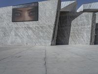 the sidewalk in front of a building with some kind of structure on the side of it