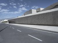 empty road near building under blue sky in daylight day with clouds overhead in daylight day