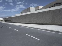 empty road near building under blue sky in daylight day with clouds overhead in daylight day